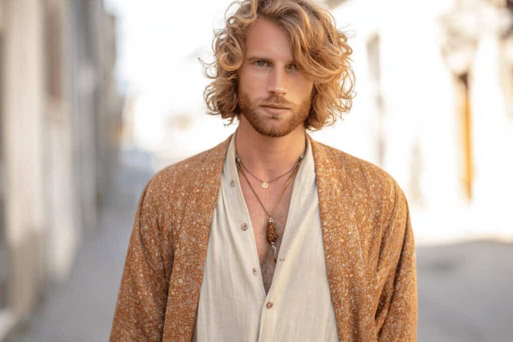 Mann mit Boho Outfit aus Leinenhemd, braunem Kimono und Halsketten