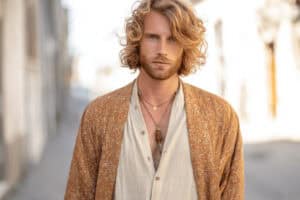 Mann mit Boho Outfit aus Leinenhemd, braunem Kimono und Halsketten