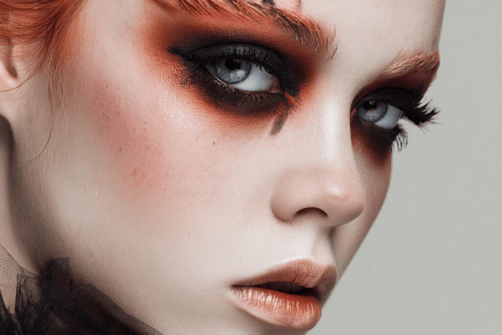 Nahaufnahme eines dramatischen Halloween Augen-Make-ups in Schwarz und Orange