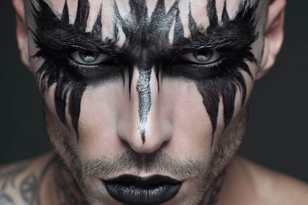 Mann mit schwarzem Halloween Make-up in Tribal-Optik