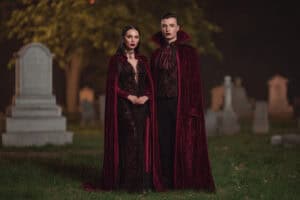 Paar in passenden Vampir Halloween Kostümen auf einem Friedhof