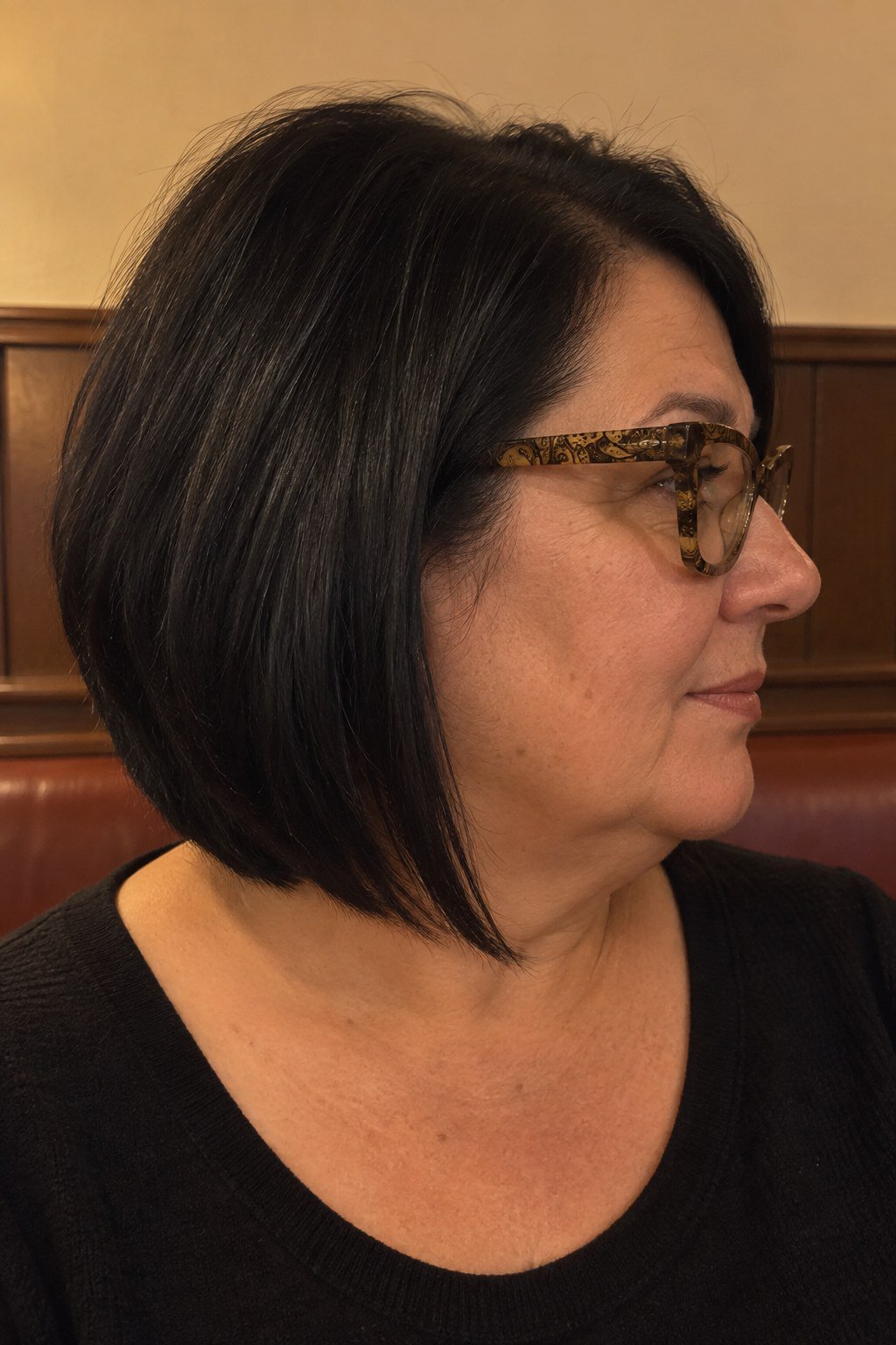 Frau mit Brille: Schwarzer Long Bob mit tiefem Nacken und gemusterter Fassung in Gold