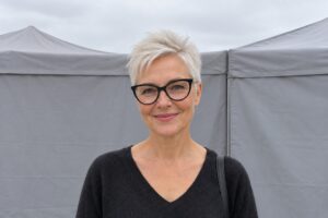 Frau mit sehr kurzem Pixie und schwarzer Brille